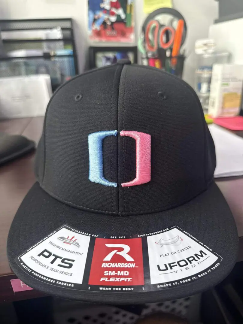 Black baseball cap with a colorful logo on the front.