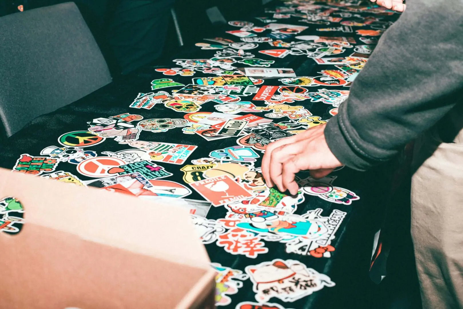Person arranging colorful stickers on a table.